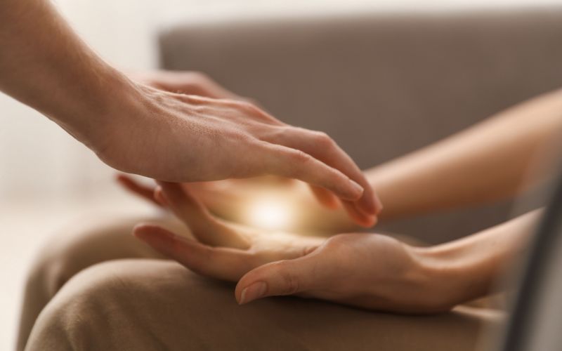 Reiki Ausbildungen in Niedernberg bei Aschaffenburg, online, zwei handflächen liegen auf Beinen und sind offen nach oben von oben kommen zwei andere Hände und in der Mitte strahlt ein Licht, Elke Maria Becker